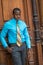 Young black businessman standing by door in New York City, looking down, thinking