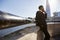 Young black businessman wearing a suit leaning on a wall at Thames embankment, London, using smartphone, low angle