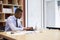 Young black businessman working alone in an office, close up