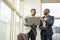 Young black businessmen standing together holding a laptop, discussing business