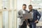 Young black businessmen standing together holding a laptop, discussing business