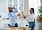 Young Black Couple Playfully Fighting With Kitchenware, Having Fun At Home