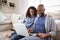 Young black couple using laptop sitting on the floor at home