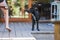 Young black Kelpie x Labrador breed dog watching boy play on swing at home on bright spring day