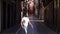 Young black male acrobat doing a ballet jump in the street.