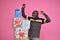 young black man feeling excited and happy and delighted, celebrating while standing next to a stack of gift boxes with fists in