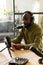 Young black man in headphones talking in microphone while reading his notes