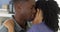 Young black man holding girlfriend and whispering into her ear