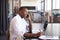 Young black man with laptop on the phone in an office