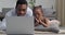 Young black man and little girl afro american father with curious emotional daughter looking at laptop lying on floor at