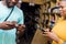 a young black man paying in a supermarket by doing a transfer with his mobile phone also holding his credit card