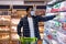Young black man in protective mask buying dairy products at supermarket during coronavirus quarantine