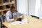 Young black man using smartphone in a boardroom, elevated view