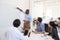 Young black man using a whiteboard in an office meeting