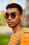 Young black man wearing piercing and sunglasses walking in park