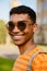 Young black man wearing piercing and sunglasses walking in park