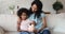 Young Black mother watch little girl putting coins to piggybank