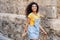 Young black tourist woman with curly hairstyle outdoors