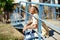 Young black woman combed with braids sitting on an urban bridge with a camera on vacation