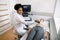 Young black woman doctor sonographer using ultrasound machine at work, holding ultrasound scanner in hand while examine