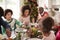 Young black woman eating Christmas dinner with her mixed race multi generation family, close up