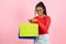 Young black woman holding shopping bags on pink backgrond.