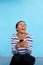 Young black woman laughing with cell phone against blue wall