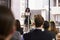 Young black woman at lectern presenting seminar to audience