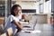 Young black woman in office with laptop smiling to camera