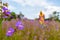 young black woman out of focus in the background in a field of flowers