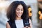 Young black woman, phone and texting in city with smile, online date and social media app for contact. Happy gen z girl