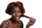Young black woman putting on blush makeup