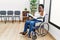 Young black woman sitting on wheelchair at waiting room doing stop sing with palm of the hand