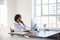 Young black woman talking on phone at her desk in an office