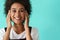 Young black woman wearing rings smiling and covering her ears