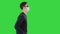 Young blind person with long cane and medical mask walking on a Green Screen, Chroma Key.