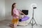 Young blogger girl spreads yoga mat and prepares equipment for filming