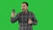 Young blogger recording video on his phone while walking on a Green Screen, Chroma Key.