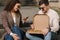 Young bloggers make photo of vegan pizza outdoor. Happy couple take food photography. Man hold pizza box on his knees