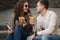 Young bloggers make selfie with slice of pizza in hands. Beautiful couple in sunglasses smile and kiss. Vegan fast food