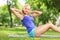 Young blond athlete doing exercises on a mat in a park