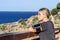 Young blond athlete woman leaning on a wood looking out to sea