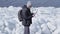 Young blond bearded handsome man in warm jacket and hat standing on the glacier checking with the map. Amazing nature of