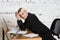 Young blond beauty businesswoman sitting at a office table with laptop, notebook and glasses in suit. Business concept.