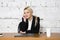 Young blond beauty businesswoman sitting at a office table with laptop, notebook and glasses in suit. Business concept.