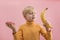 Young blond boy choosing between fruits and sweets. Child holding doughnut and banana. Healthy Food
