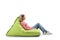 Young blond casual woman sitting on a green bean bag