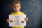 Young blond child, holding sign in support to peace, no war wanted, kid wishing peaceful life