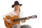 A young blond cowgirl playing on a coustic guitar