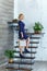 Young blond elegant woman with shopping bags on the stairs